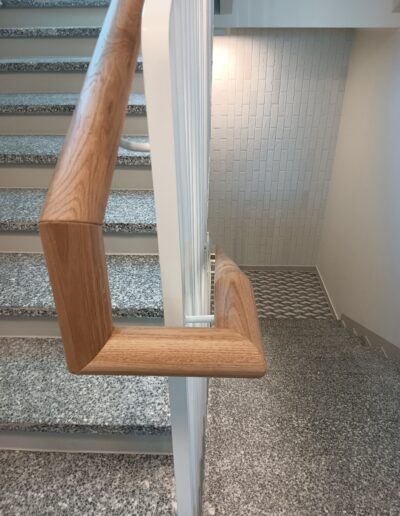 Eritellimusel metallpiirde ja puidust käsipuuga trepp terrazzo astmetega.